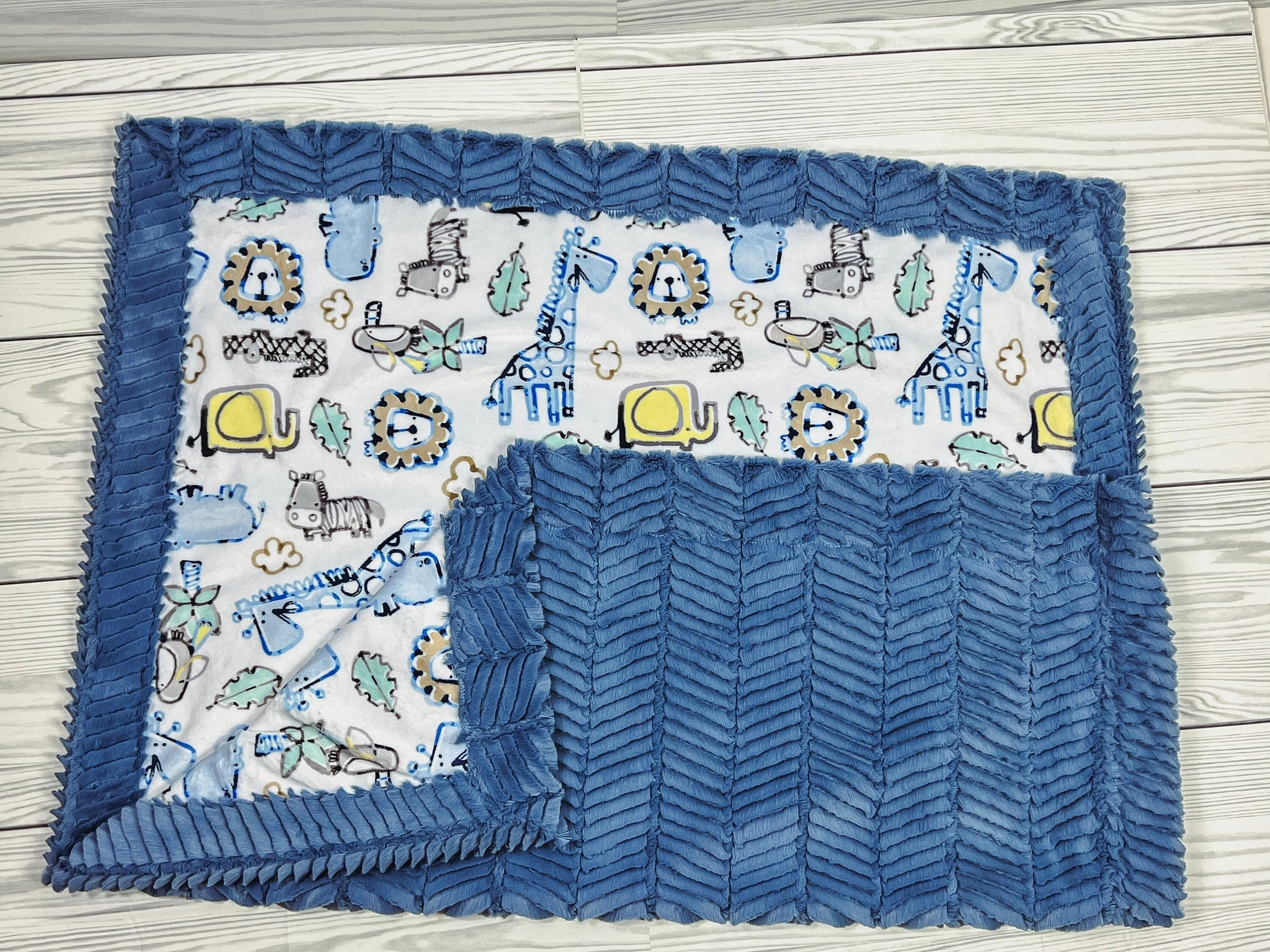 The blanket has a soft feel and can be used on both sides. It has blue giraffes, yellow turtles and gray tigers.
A single embroidered name is optional and is an additional charge.